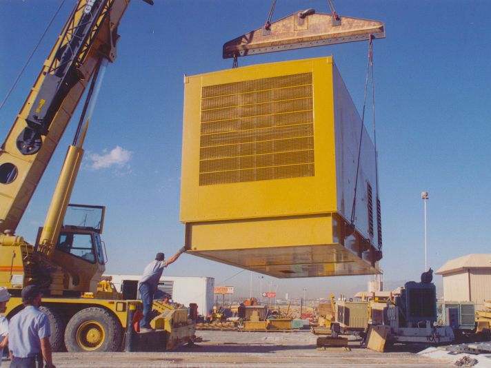 Large generator enclosure being lifted into position for installation