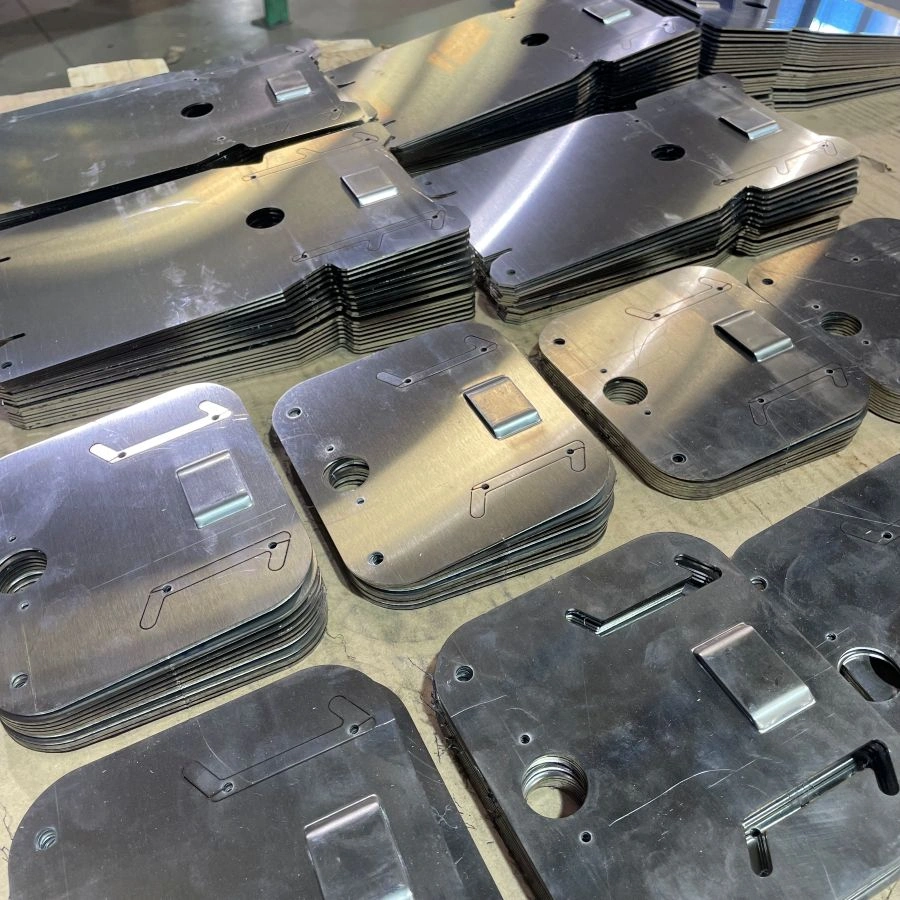 Stacks of stainless steel parts with embossed slots and laser-cut features