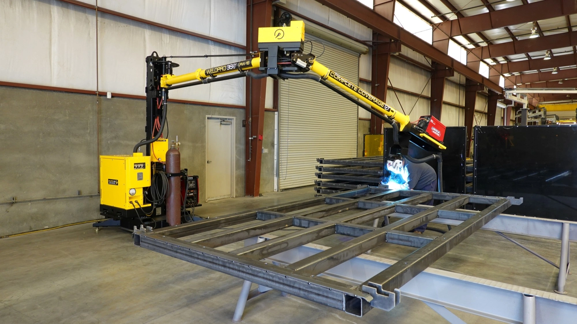 Welder performing MIG weld on a large pallet weldment with the WP360 LRW-18 MIG welding boom arm.